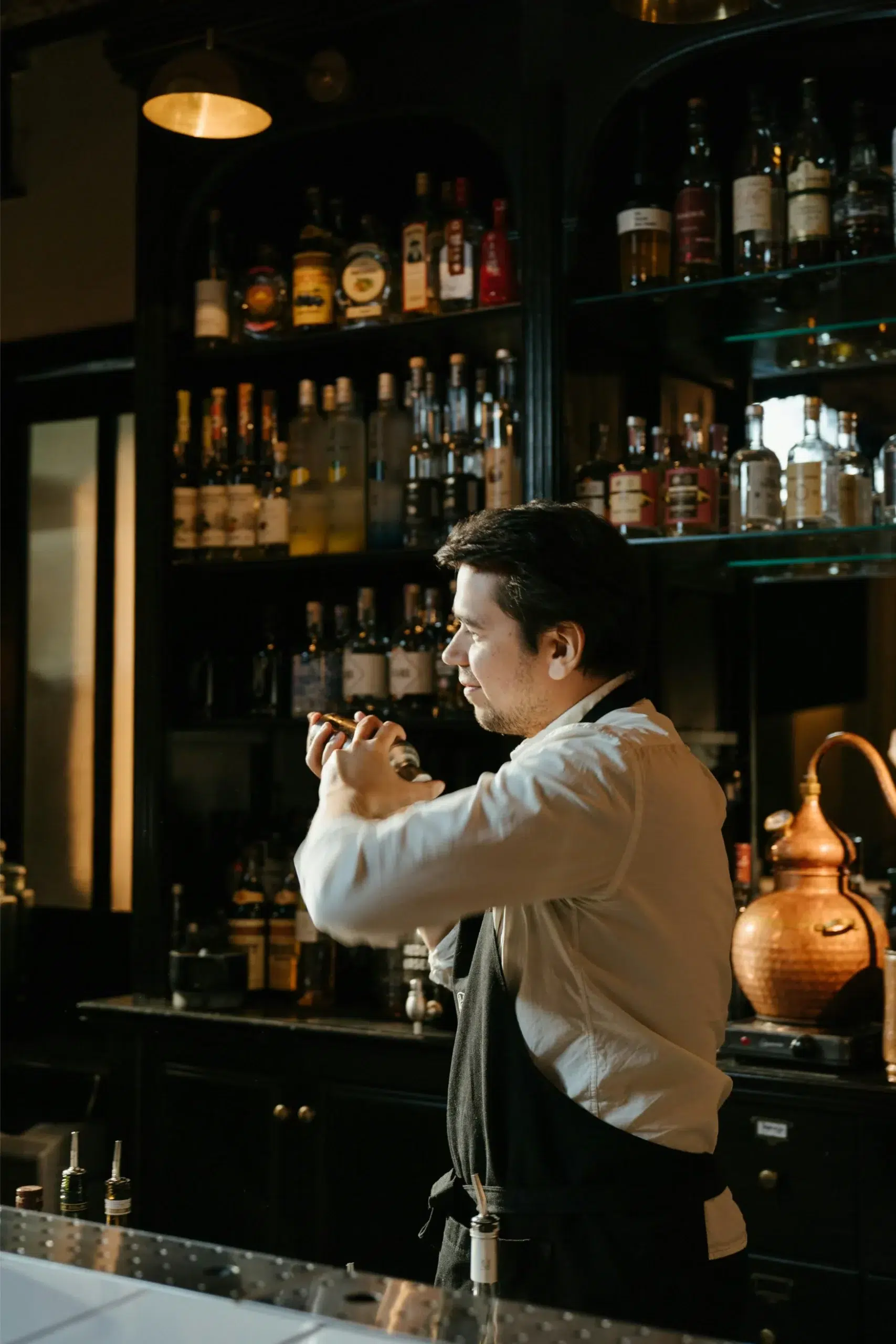 Bartender mixing cocktail behind bar counter