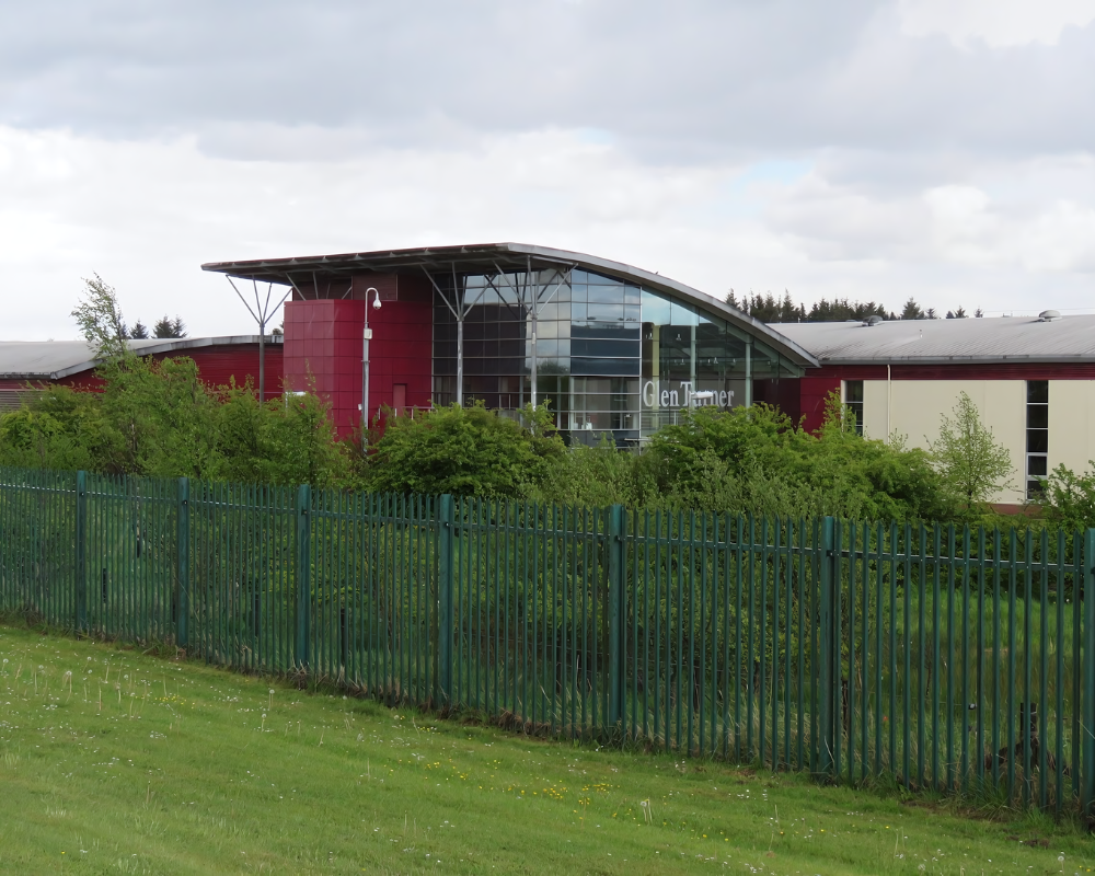 Modern building with red facade and green fence